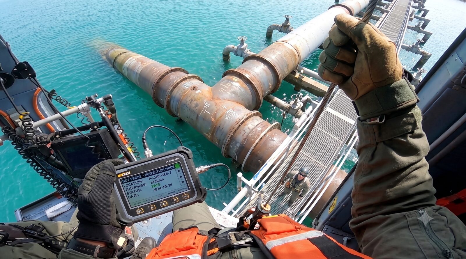 Pipeline inspection with an NDT tester over water, first person