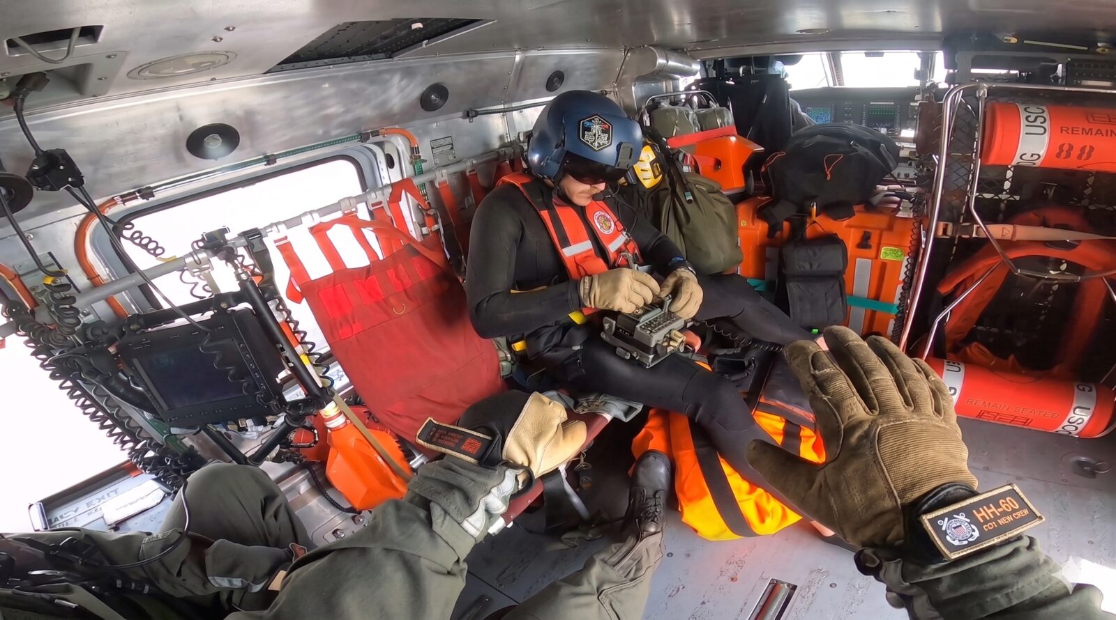 Rescue swimmer preparing equipment inside a rescue helicopter